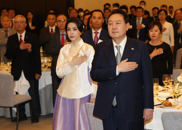 윤석열 대통령과 김건희 여사가 22일(현지시간) 캐나다 토론토 한 호텔에서 열린 동포 만찬간담회에서 국기에 경례를 하고 있다. 연합뉴스