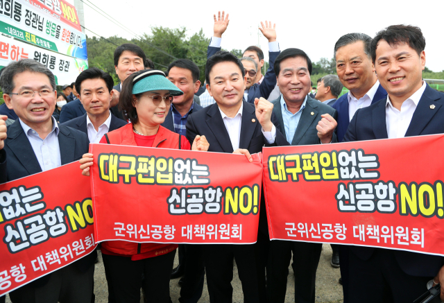 원희룡 국토교통부 장관이 26일 대구경북 통합신공항 부지인 경북 군위군 소보면 내의리를 방문해 현장을 살펴본 뒤 지역 주민 및 관계자들과 통합신공항 건설에 따른 군위군의 대구 편입을 촉구하는 현수막을 들고 파이팅을 하고 있다. 연합뉴스