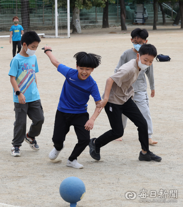 실외마스크 착용 의무가 해제된 26일 오전 대구 북구의 한 초등학교 운동장에서 학생들 중 일부가 마스크를 벗은 채 축구를 하고 있다. 이날부터 50인 이상이 참석하는 야외 집회, 공연, 경기 등에서도 마스크 착용 의무가 해제되면서 약 1년 5개월 만에 실외 마스크 착용 의무가 전면 해제됐지만 시민들을 마스크를 벗는 데 주저하는 모습이었다. 반면 이날 코로나19 일일 신규 확진자는 1만 4168명을 기록하면서 77일 만에 최저치를 기록하면서 감소세를 이어나갔다. 안성완 기자 asw0727@imaeil.com