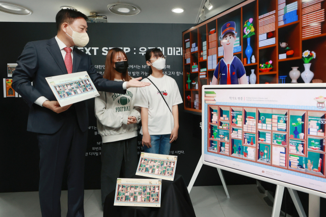 22일 서울 중구 우표박물관에서 열린 2022 대한민국 우표전시회에서 어린이들이 기존 기념우표 원화(우표 제작을 위한 그림)를 재해석한 대체불가토큰(NFT) 관련 설명을 듣고 있다. 연합뉴스