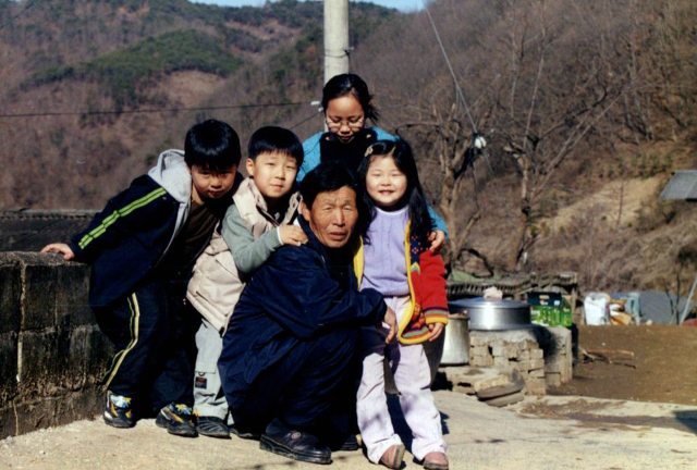 고 최홍수 씨가 손자, 손녀들에게 둘러싸여 즐거운 한 때를 보내고 있는 모습. 최상열 씨 제공.