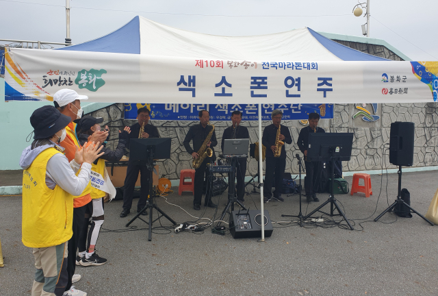봉화송이전국마라톤대회를 찾은 대구마라톤협회 회원들이 메아리색소폰연주단의 색소폰 연주를 들으며 박수치고 있다. 이현주 기자