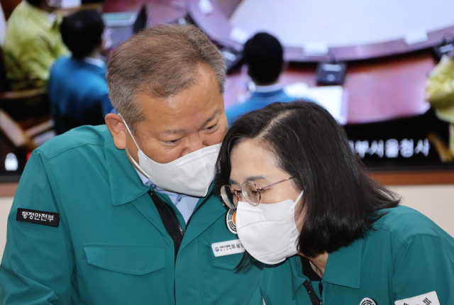 이상민 행정안전부 장관과 김현숙 여성가족부 장관이 지난 9월 23일 정부서울청사에서 열린 코로나19 대응 중앙재난안전대책본부 회의에 참석해 대화하고 있다. 연합뉴스
