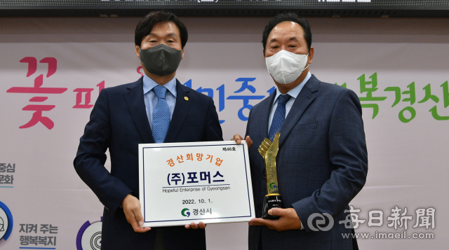 조현일 경산시장이 4일 올해 4분기 경산 희망기업으로 선정된 (주)포머스 강준기(오른쪽) 대표에게 트로피와 현판을 전달하고 있다. 경산시 제공