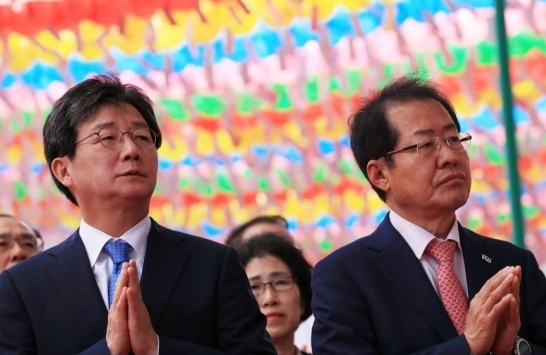 지난 2018년 5월 22일 부처님오신날에 서울 종로 조계사에서 만난 유승민 당시 바른미래당 대표와 홍준표 당시 자유한국당 대표. 연합뉴스