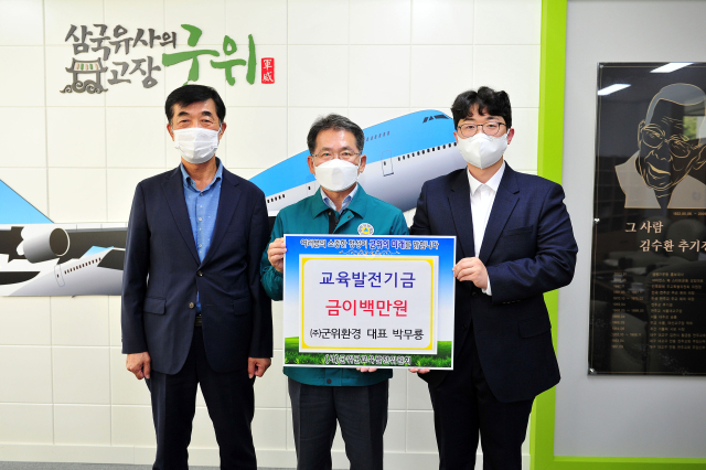 경북 군위군의 ㈜군위환경 박무룡(오른쪽) 대표가 김진열(가운데) 군수에게 교육발전기금을 기탁하고, 기념 사진을 촬영하고 있다. 군위군 제공
