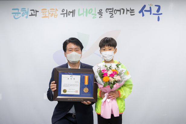 강범석 인천서구청장이 길거리 쓰레기더미를 정리한 조상우 군에게 착한 어린이 상을 전달한 뒤 포즈를 취했다. 인천 서구청 제공