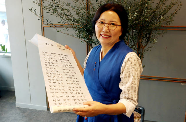 내방가사 작가인 권숙희 씨가 자신이 풀이한 정인지서(훈민정음 혜례에 실린 정인지의 서문)를 가사로 풀이한 두루마리 작품을 펼쳐 보이고 있다. 이화섭 기자.