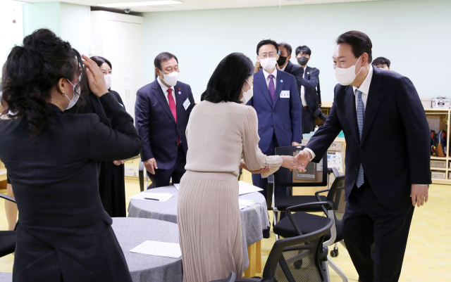 윤석열 대통령이 27일 세종시 아이누리 어린이집에서 열린 영유아 가족·보육종사자 간담회에서 참석자들과 악수하고 있다. 연합뉴스