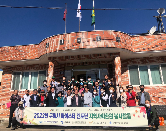 구미시 마이스터멘토단 관계자들이 구미 무을면 백자리에서 재능 나눔 봉사활동을 하며 기념촬영하고 있다. 구미시 제공