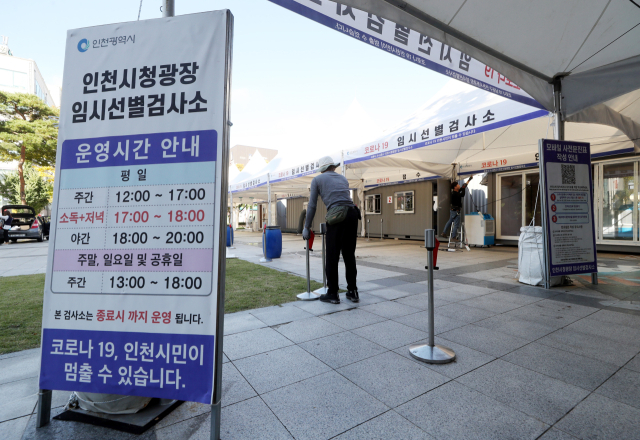 13일 오전 인천시청 앞 광장에 설치된 신종 코로나바이러스 감염증(코로나19) 임시 선별검사소에서 시설업체 관계자가 철거 작업을 하고 있다. 인천시는 이날부터 이 검사소를 시작으로 총 3곳의 임시 선별검사소를 단계적으로 운영 종료한다고 밝혔다. 연합뉴스