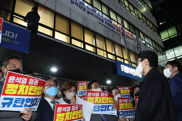19일 저녁 민주연구원 압수수색을 시도하고 있는 검찰과 더불어민주당 의원들이 대치하고 있는 서울 여의도 더불어민주당 중앙당사에 사무직당직자노조 관계자가 검찰 규탄 플래카드를 내걸고 있다. 연합뉴스