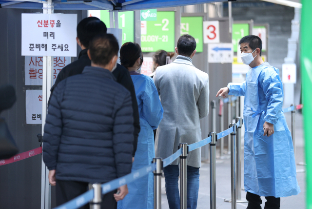 코로나19 신규 확진자가 2만9천503명 발생한 19일 오전 서울 용산구보건소에 마련된 선별진료소를 찾은 시민들이 검사를 받기 위해 줄을 서고 있다. 연합뉴스