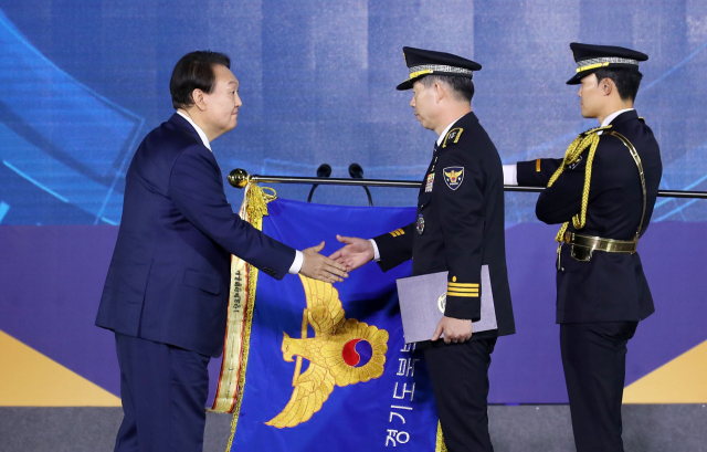 윤석열 대통령이 21일 인천시 연수구 송도컨벤시아에서 열린 제77주년 경찰의날 기념식에서 경기북부경찰청 이문수 치안감에게 대통령단체표창을 수여하고 있다. 연합뉴스