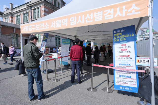 23일 오후 서울역 코로나19 임시선별검사소에서 피검자들이 줄을 서 있다. 이날 코로나19 신규 확진자는 2만6천256명 발생했으며 이는 1주일 전인 지난 16일보다 4천800명 늘어 증가세를 보이고 있다. 연합뉴스