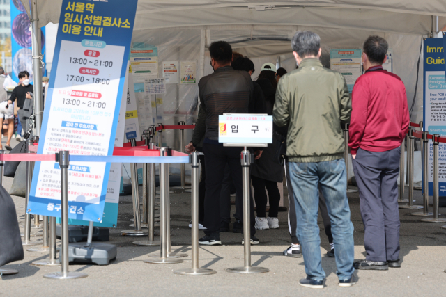 23일 오후 서울역 코로나19 임시선별검사소에서 피검자들이 줄을 서 있다. 이날 코로나19 신규 확진자는 2만6천256명 발생했으며 이는 1주일 전인 지난 16일보다 4천800명 늘어 증가세를 보이고 있다. 연합뉴스