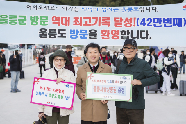 남한권 울릉군수가 지난 26일 오전 42만번째 울릉 입도객을 환영하며 선물을 증정하고 있다. 울릉군 제공.