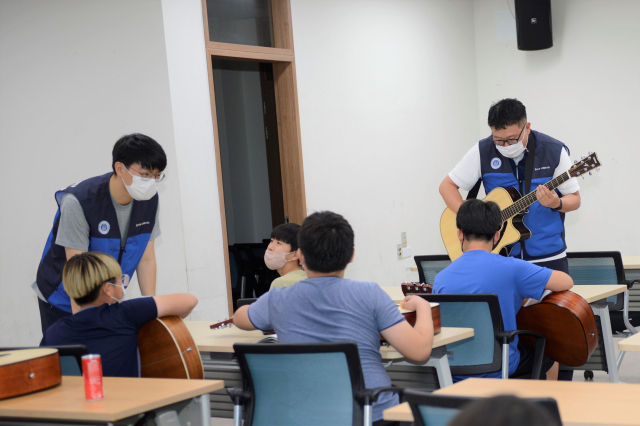 한울본부 제영훈 주임, 임기훈 대리가 아이들에게 재능기부로 기타수업을 진행하고 있다. 한울본부 제공