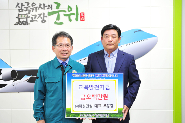 조용경(오른쪽) ㈜화성건설 대표가 교육발전기금을 기탁한 후 김진열 군위군수와 기념 사진을 촬영하고 있다. 군위군 제공