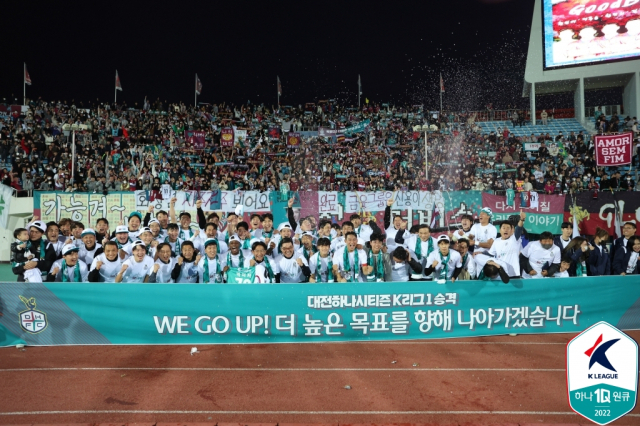 대전하나시티즌 선수들과 이민성 감독, 코치진 등이 29일 김천종합운동장에서 김천 상무와 치른 하나원큐 K리그 2022 승강 플레이오프(PO) 2차전 원정 경기에서 이겨 1부로 승격된 뒤 기념촬영하고 있다. 연합뉴스