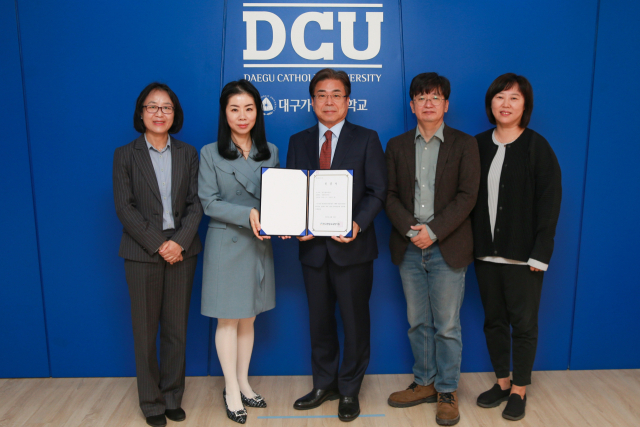 성한기(가운데) 대구가톨릭대 총장직무대행과 식품영양학과 교수들이 평가인증서를 들고 기념촬영을 하고 있는 모습. 대구가톨릭대 제공