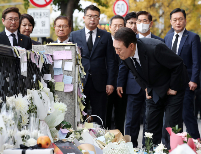 윤석열 대통령이 1일 서울 용산구 이태원역 1번 출구 앞 이태원 참사 추모 공간을 방문, 헌화한 뒤 시민들의 추모 메시지를 읽고 있다. 연합뉴스