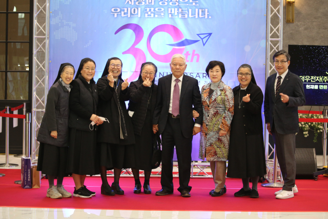 사회복지법인 교육회 관계자들과 이재민(왼쪽 다섯 번째) 덕우전자㈜ 회장 등이 지난 4일 덕우전자 창립 30주년 기념식에서 기념촬영하고 있다. 덕우전자 제공