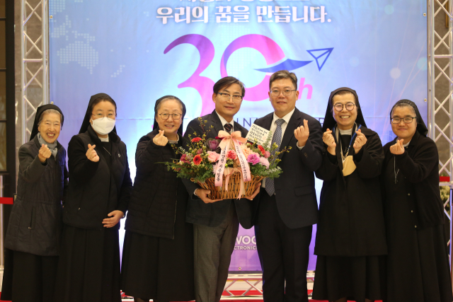 사회복지법인 교육회 관계자들과 이준용(왼쪽 다섯 번째) 덕우전자㈜ 대표이사 등이 지난 4일 덕우전자 창립 30주년 기념식에서 기념촬영하고 있다. 덕우전자 제공