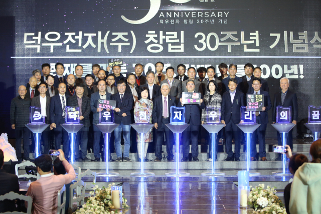 구미국가산업단지 내 덕우전자㈜ 이재민 회장, 이준용 대표이사 등이 지난 4일 구미 BW웨딩에서 임직원 등 관계자들과 창립 30주년 기념식을 하고 있다. 덕우전자 제공