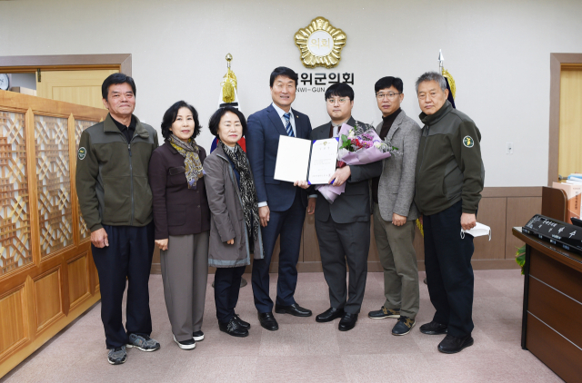 박수현(가운데) 경북 군위군의회 의장이 신임 정책지원관에게 임명장을 수여하고 의원들과 함께 기념 사진을 촬영하고 있다. 군위군의회 제공.