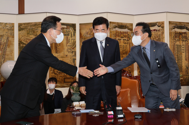 김진표 국회의장(가운데)이 7일 오전 국회 의장실에서 국민의힘 주호영 원내대표(왼쪽), 더불어민주당 박홍근 원내대표와 회동 전 인사를 나누고 있다. 연합뉴스