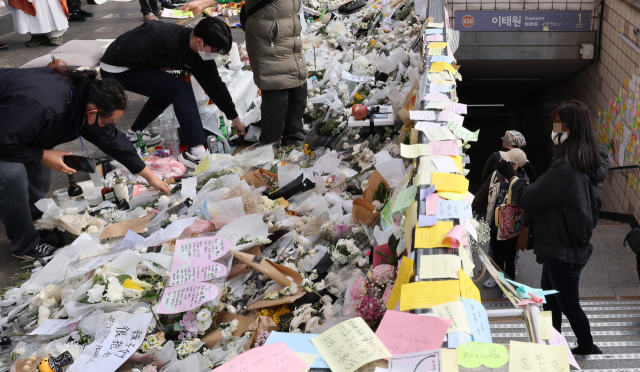 7일 이태원 참사 희생자 추모공간인 이태원역 1번 출구에서 자원봉사자들이 꽃을 정리하고 있다. 국가애도기간은 지난 5일 종료했다. 연합뉴스