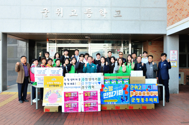 경북 군위군과 기관·단체들이 군위고등학교를 방문, 대학수학능력에 응시하는 수험생들과 기념 사진을 촬영하고 있다. 군위군 제공
