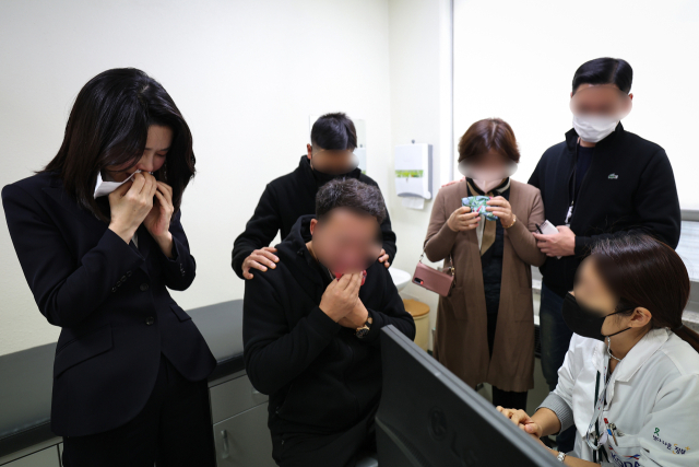 윤석열 대통령의 부인 김건희 여사가 10일 서울 양천구 이대목동병원 장기이식센터에서 이태원 참사로 뇌사 판정을 받은 뒤 장기기증을 결정한 국군 장병의 가족을 위로하고 있다. 연합뉴스