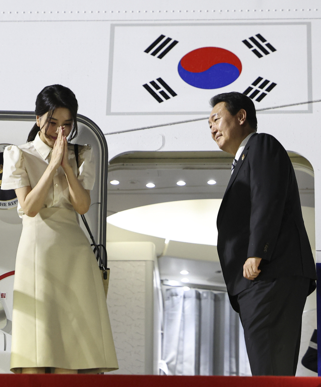 윤석열 대통령과 김건희 여사가 한·아세안 정상회의 등의 일정을 마친 뒤 주요 20개국(G20) 정상회의가 열리는 인도네시아 발리로 출국하기 위해 13일(현지시간) 캄보디아 프놈펜국제공항에 도착, 공군 1호기에서 인사하고 있다. 연합뉴스