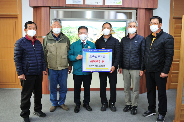 경북 군위군 부계면파크골프협회 회원들이 김진열 군위군교육발전위원회 이사장에게 교육발전기금 200만원을 기탁하고 기념 사진을 촬영하고 있다. 군위군 제공