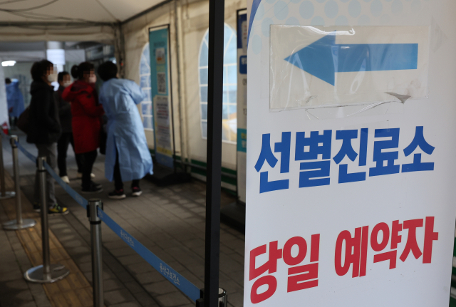 16일 오전 서울 용산구보건소 코로나19 선별진료소에서 시민들이 코로나19 검사를 받기 앞서 관계자와 대화하고 있다. 연합뉴스