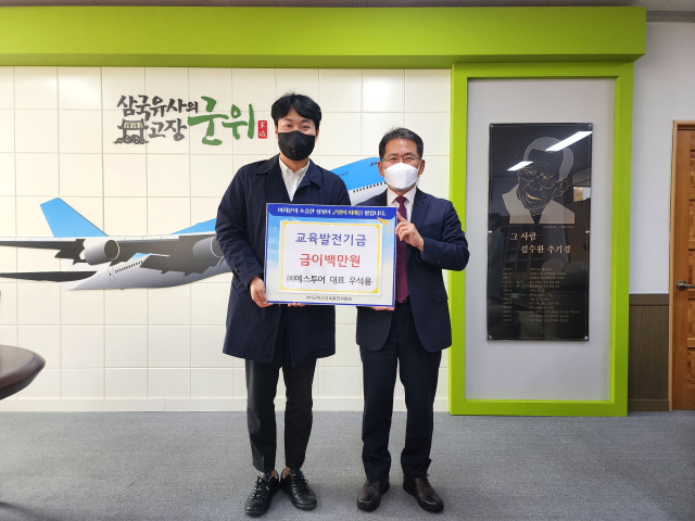 경북 군위군의 우석용(왼쪽) ㈜예스투어 대표가 김진열 군위군교육발전위원회 이사장에게 교육발전기금을 기탁하고 기념 사진을 촬영하고 있다. 군위군 제공