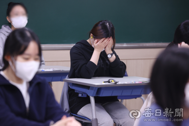 2023학년도 대학수학능력시험일인 지난달 17일 대구여자고등학교에서 입실을 마친 수험생이 간절한 마음으로 기도하고 있다. 안성완 기자 asw0727@imaeil.com