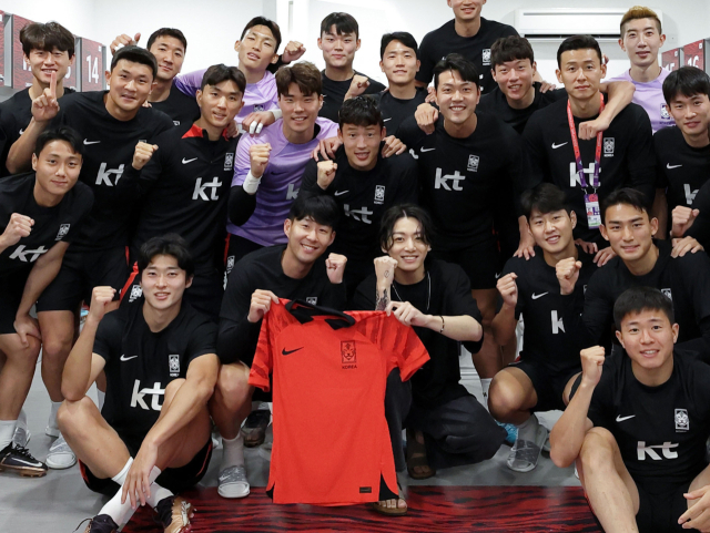 방탄소년단(BTS) 정국이 19일(현지시간) 카타르 도하의 2022 카타르 월드컵 한국 축구 대표팀 훈련장인 알에글라 훈련장을 찾아 손흥민 등 선수들과 기념촬영을 하고 있다. 연합뉴스