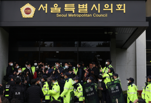 자료사진. 지난 15일 오후 서울시의회 본회의장에서 서울특별시 미디어재단 TBS 설립 및 운영에 관한 조례 폐지조례안 등 안건에 대한 회의가 진행 중인 가운데 입장하려던 TBS 구성원들이 경찰에게 저지당하고 있다. 연합뉴스