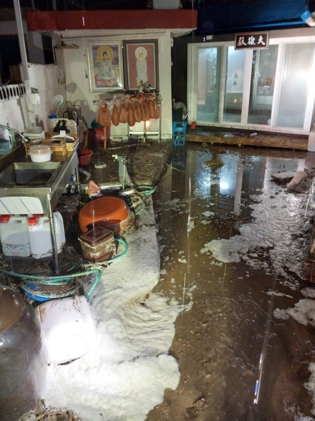 22일 오후 포항시 북구 칠포리에 내린 집중 호우로 주택 마당이 침수된 것을 소방대원들이 안전조치하고 있다. 포항북부소방서 제공.