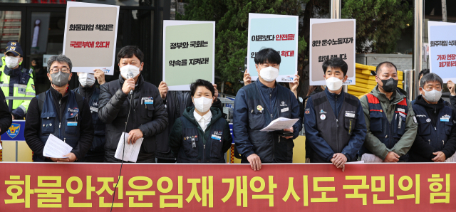 민주노총 공공운수노조 조합원들이 23일 오전 서울 영등포구 국민의힘 당사 앞에서 화물 총파업 연대 및 대체수송 거부 기자회견을 열고 있다. 이들은 24일 예고된 화물연대 총파업 관련 대체수송을 거부하는 등 연대하겠다고 밝히는 한편 당정협의를 통해 합의한 안전운임 연장안에 화주책임이 삭제돼 있다며 폐기를 요구했다. 연합뉴스