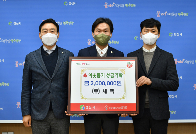 김정우(오른쪽) ㈜새벽 대표가 28일 이웃돕기 성금 200만원을 경산시에 기탁했다.
