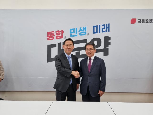 김진열(오른쪽) 경북 군위군수가 행정안전위원회 소위원회 대구 편입 법률안이 처리된 후 국민의힘 주호영(왼쪽) 원내대표를 찾아가 감사의 인사를 전하고 있다. 군위군 제공