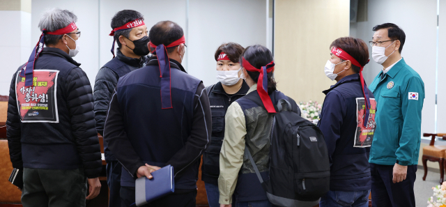 민주노총 공공운수노조 화물연대본부(이하 화물연대) 관계자들이 28일 오후 세종시 정부세종청사 국토교통부에서 총파업 시작 후 첫 교섭을 하기 위해 회의실에 입장해 대화하고 있다. 오른쪽은 어명소 국토교통부 제2차관. 연합뉴스