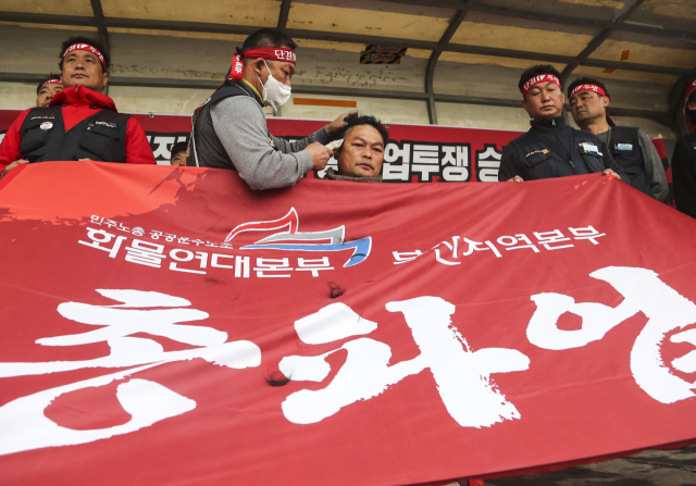 화물연대본부 총파업 엿새째인 29일 오후 부산 강서구 부산신항 삼거리에서 부산본부 조합원들이 정부의 업무개시명령에 반발하는 집회를 열고 부산지역본부 송천석 본부장이 삭발하고 있다. 연합뉴스