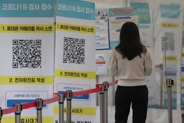 코로나19 신규 확진자가 2만2천327명 발생한 28일 오후 서울역광장에 마련된 임시선별검사소를 찾은 시민이 전자문진표를 작성하고 있. 연합뉴스