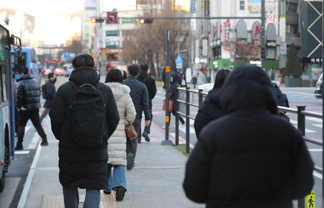 서울에 한파 경보가 내려진 30일 오전 서울 광화문네거리에서 중무장 듯 옷을 차려입은 시민이 횡단보도로 걸어가고 있다. 연합뉴스