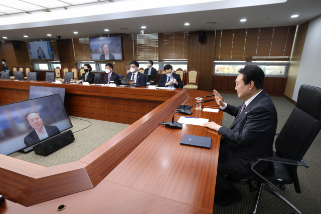 윤석열 대통령이 23일 서울 용산 대통령실 청사에서 화상으로 테슬라 최고경영자(CEO) 일론 머스크를 접견한 뒤 작별인사를 하고 있다. 연합뉴스